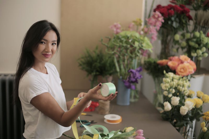 Artisan fleuriste Interflora composant un bouquet avec passion